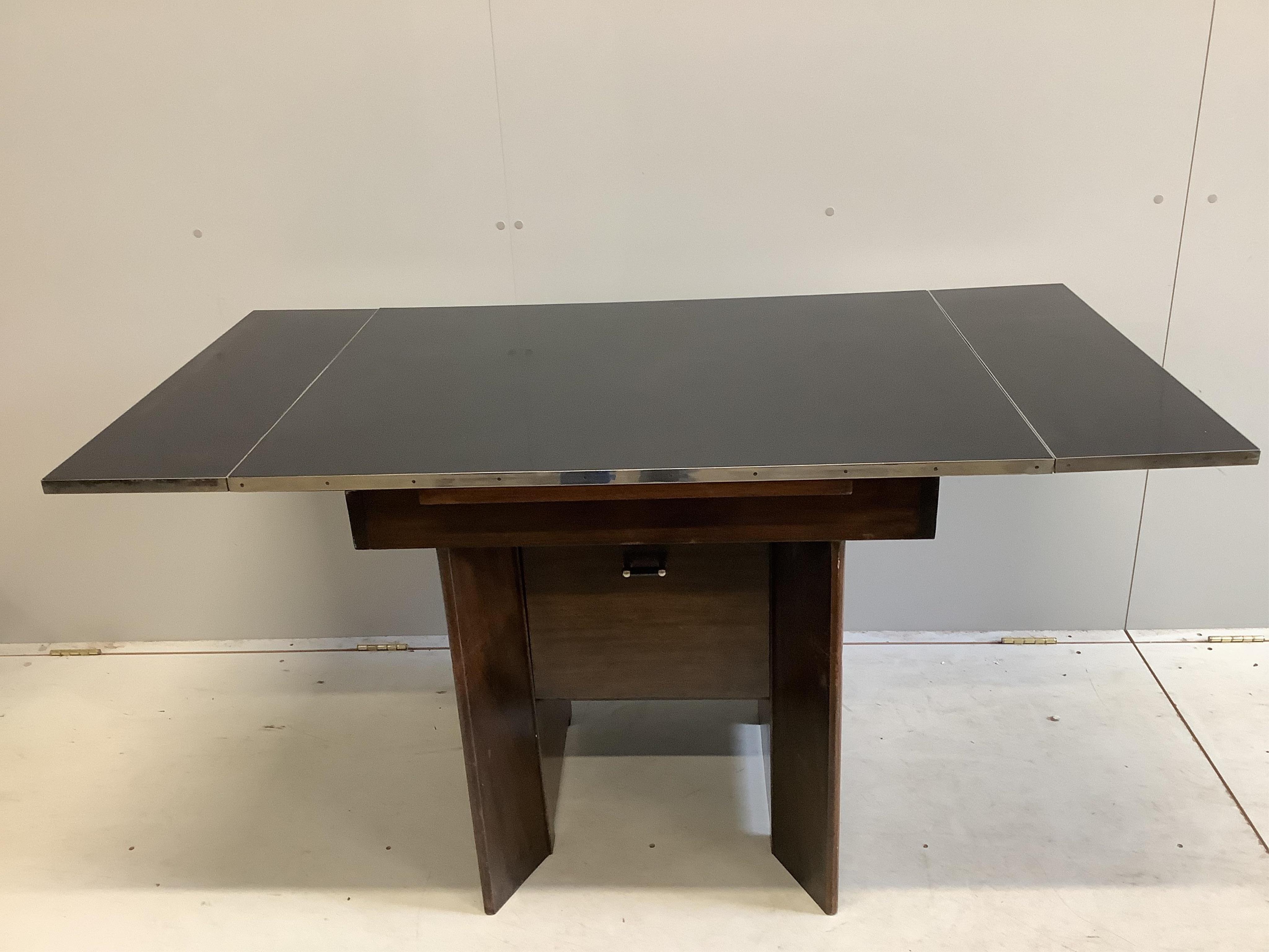 A mid century chrome mounted draw leaf extending dining table, width 145cm extended, depth 76cm, height 76cm. Condition - fair